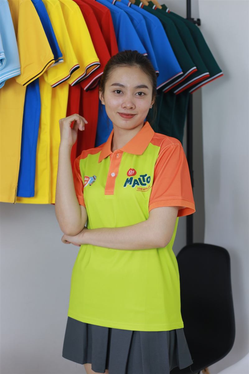 Áo polo phối màu xanh chanh và cam in logo thương hiệu, may tại xưởng Hoàng Gia Uniform